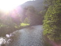 Slunce svými paprsky přímo něžně dobývá řeku Moravu nad lávkou k nádraží v Raškově.